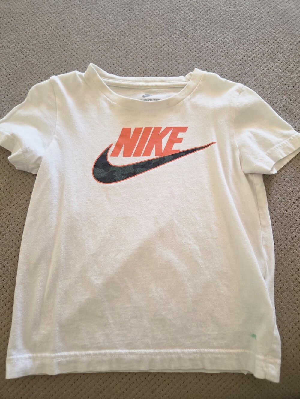 Nike white t-shirt with a camouflage-filled swoosh and orange lettering youth 4t